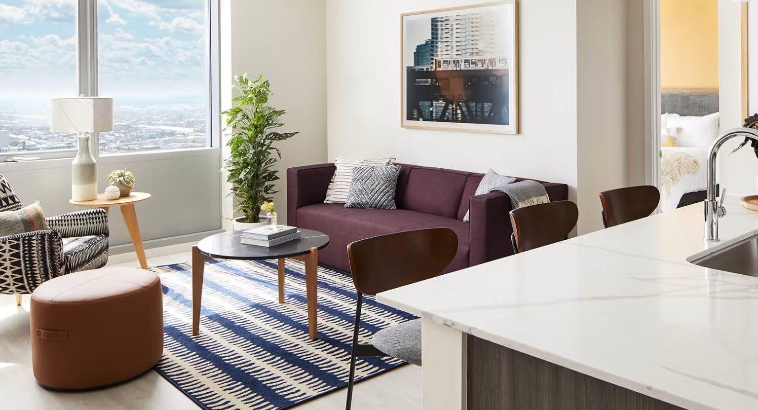 Open-concept apartment at Sentral Michigan Avenue in Chicago, featuring a modern kitchen island, comfortable living area, and large windows