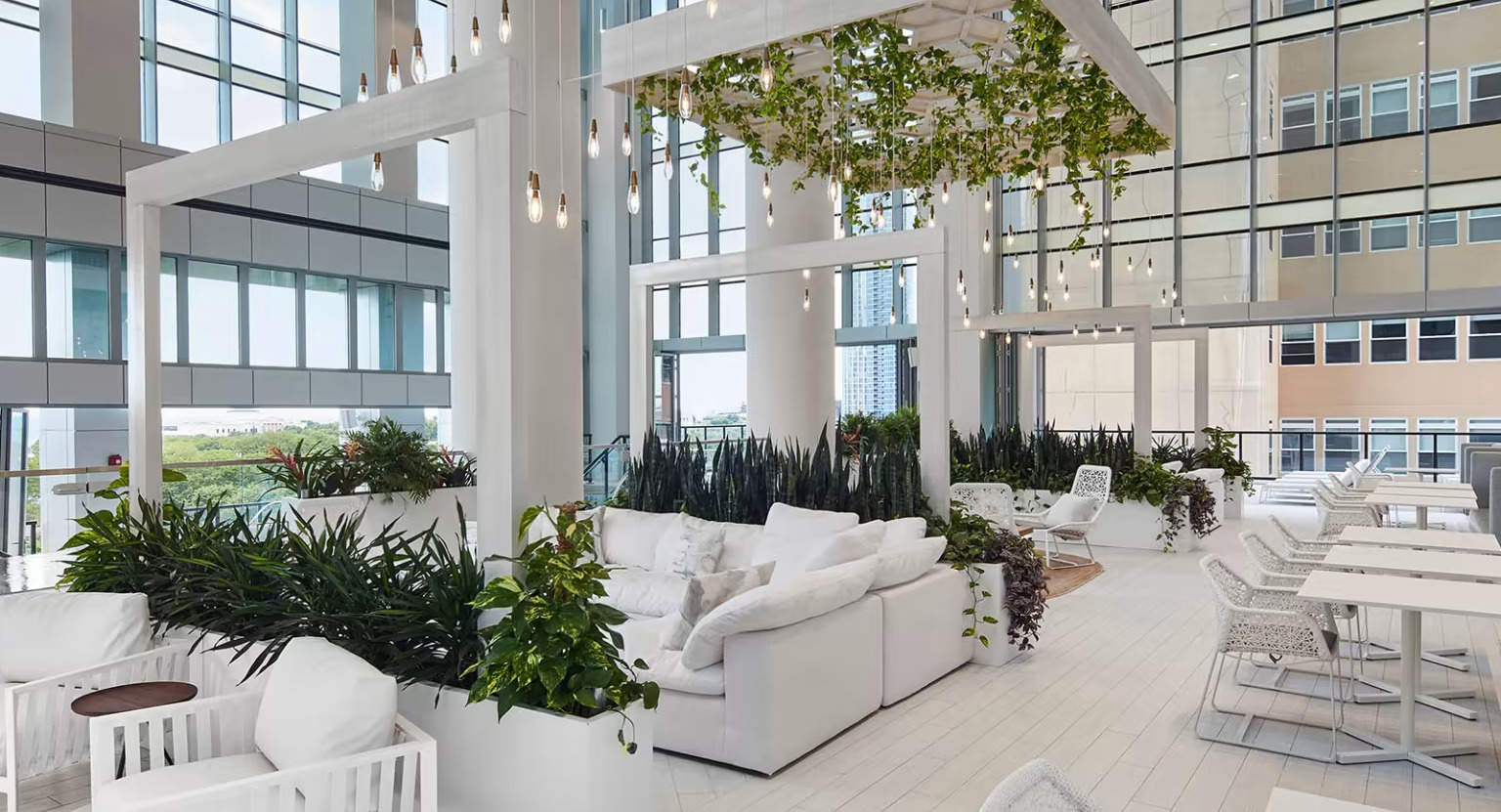 Expansive resident lounge at Sentral Michigan Avenue in Chicago, featuring lush indoor gardens, comfortable seating, and abundant natural light