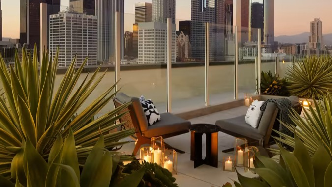 Luxurious rooftop lounge at Sentral Michigan Avenue in Chicago, featuring comfortable seating, lush greenery, and stunning downtown skyline views at sunset