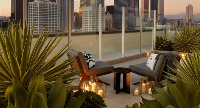 Luxurious rooftop lounge at Sentral Michigan Avenue in Chicago, featuring comfortable seating, lush greenery, and stunning downtown skyline views at sunset