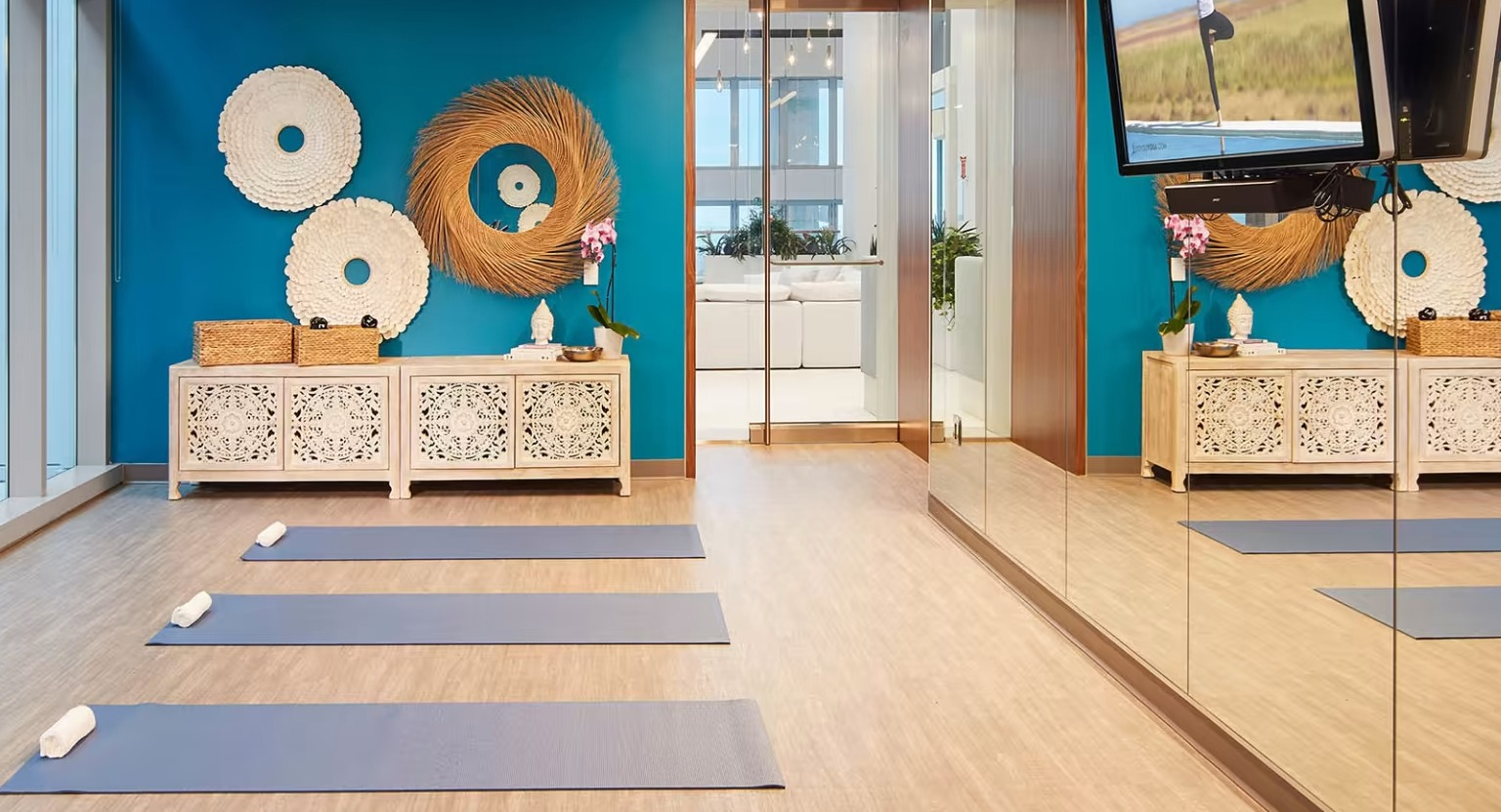 Serene yoga and meditation studio at Sentral Michigan Avenue in Chicago, featuring vibrant blue walls, yoga mats, and mirrors