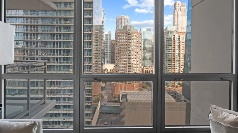 Floor-to-ceiling windows at Shoreham and Tides apartments in Chicago, showcasing skyline views and abundant natural light in the living area