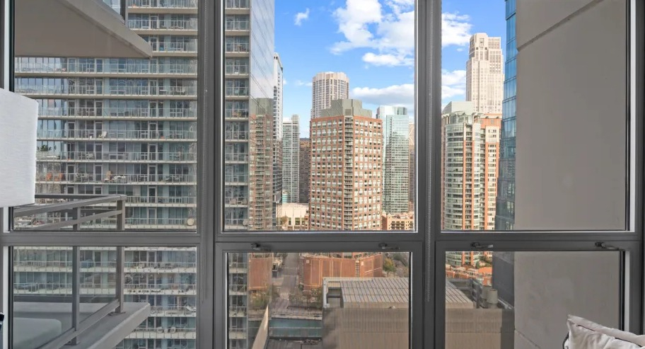 Floor-to-ceiling windows at Shoreham and Tides apartments in Chicago, showcasing skyline views and abundant natural light in the living area