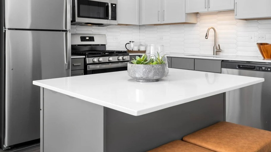 Kitchen with a large island and cushioned stools at Shoreham and Tides apartments in Chicago, perfect for quick meals or entertaining friends