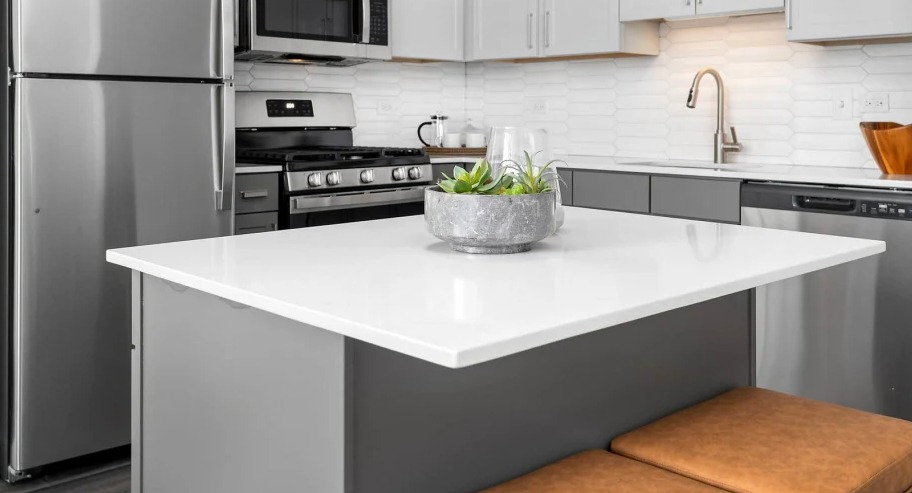 Kitchen with a large island and cushioned stools at Shoreham and Tides apartments in Chicago, perfect for quick meals or entertaining friends