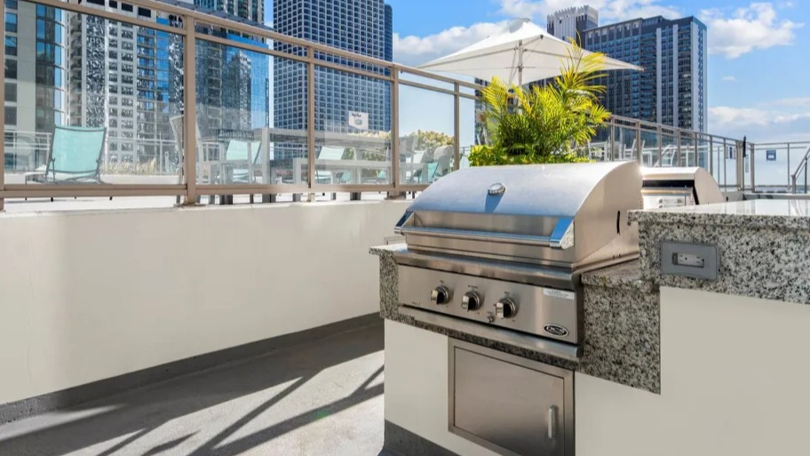Modern outdoor grilling station with stainless steel barbecue and city views at Shoreham and Tides apartments in Chicago