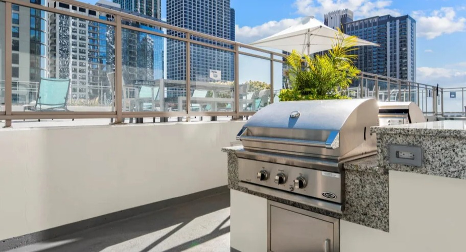Modern outdoor grilling station with stainless steel barbecue and city views at Shoreham and Tides apartments in Chicago
