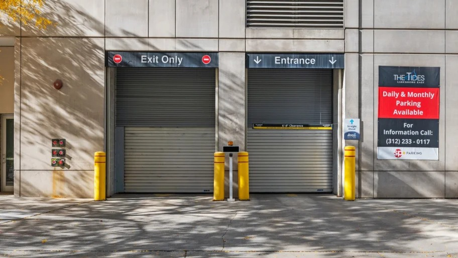 Secure parking garage entrance and exit with signage at Shoreham and Tides apartments in Chicago