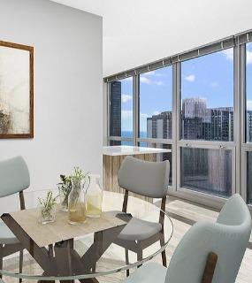 Dining area with floor-to-ceiling windows and lake views at Shoreham and Tides apartments in Chicago