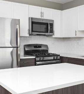 Modern kitchen with stainless steel appliances at Shoreham and Tides apartments in Chicago