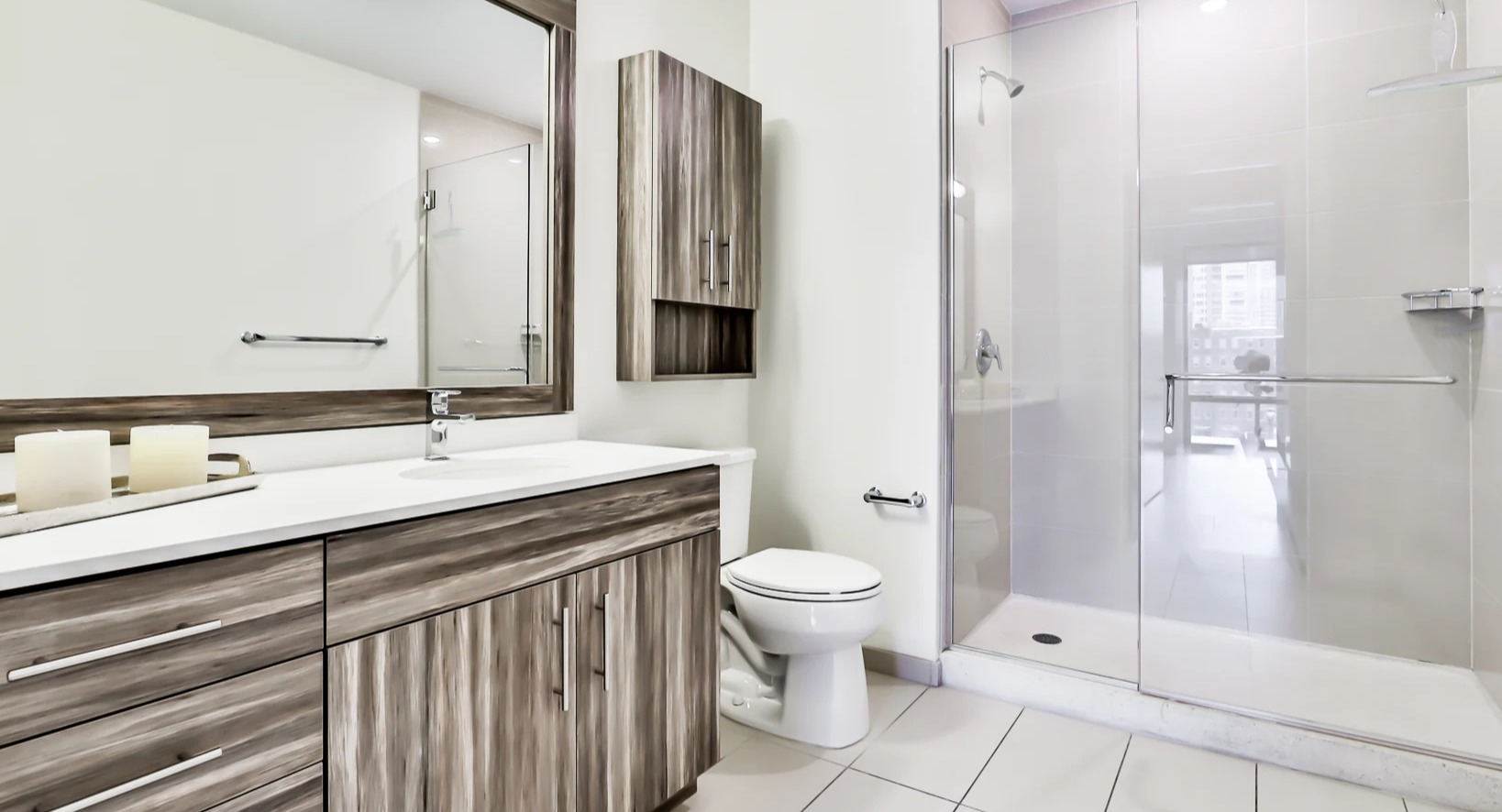 Modern bathroom at Sienna in Chicago, featuring a spacious walk-in shower with a glass enclosure and a stylish vanity