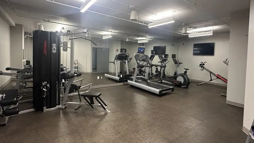Full-service gym at Sienna in Chicago, featuring a variety of cardio equipment, free weights, and weight machines for a complete workout