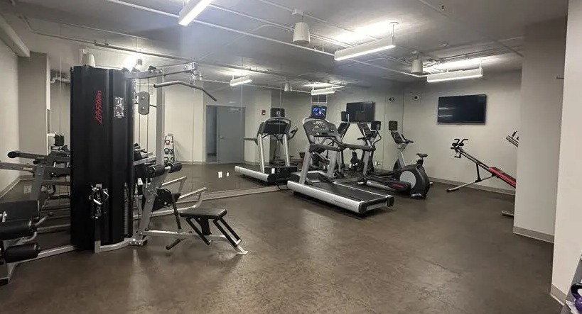 Full-service gym at Sienna in Chicago, featuring a variety of cardio equipment, free weights, and weight machines for a complete workout