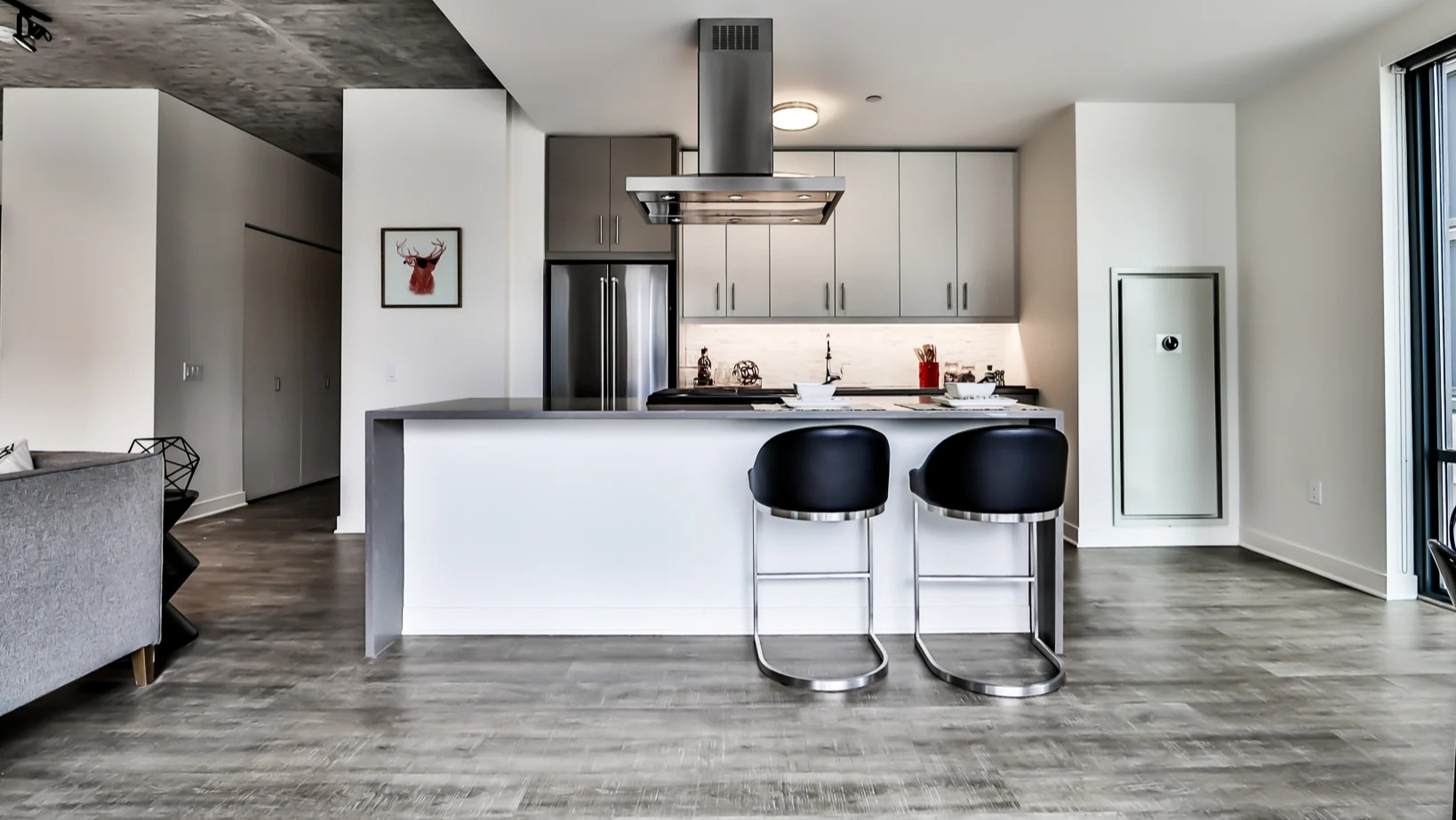 Chic apartment kitchen at Sienna in Chicago, featuring a large island with bar stools, stainless steel appliances, and ample counter space