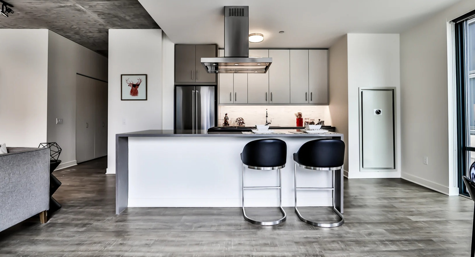 Chic apartment kitchen at Sienna in Chicago, featuring a large island with bar stools, stainless steel appliances, and ample counter space