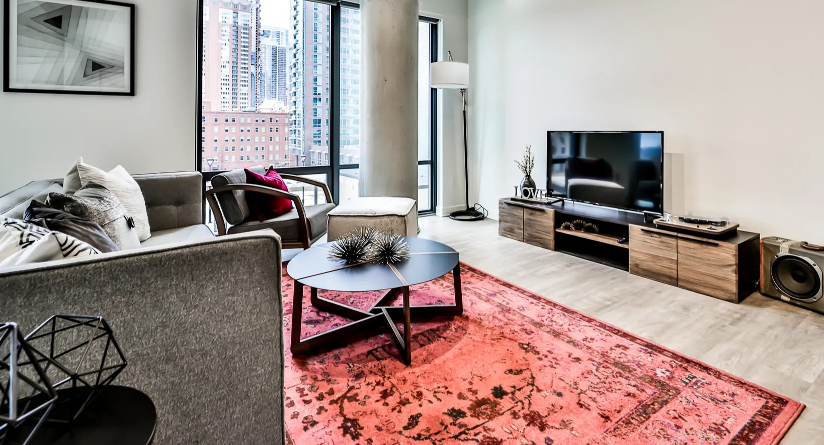 Contemporary living room at Sienna in Chicago, featuring a comfortable sofa, stylish rug, and expansive windows with urban views