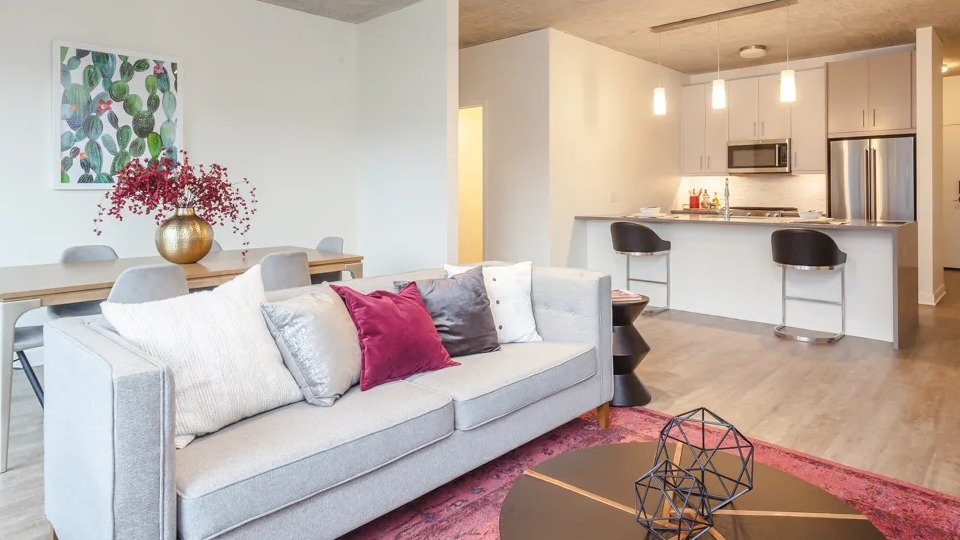 Vibrant open-concept apartment at Sienna in Chicago, featuring a cozy sofa, dining area, and modern kitchen with an island
