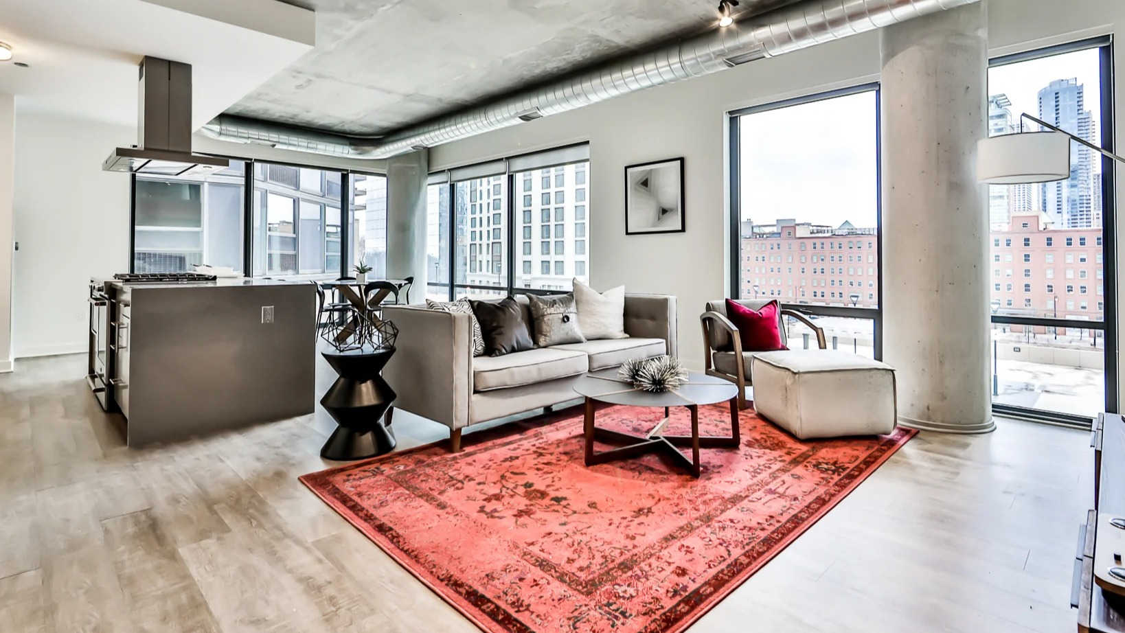 Spacious open-concept living room and kitchen at Sienna in Chicago, featuring a cozy sofa, modern dining area, and sleek kitchen island