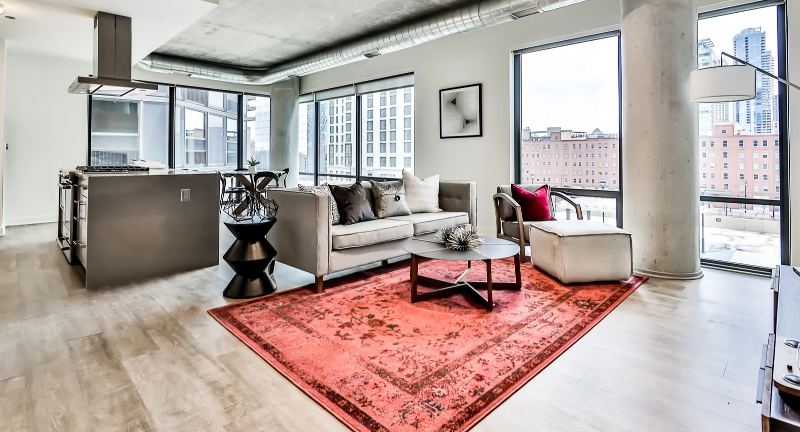 Spacious open-concept living room and kitchen at Sienna in Chicago, featuring a cozy sofa, modern dining area, and sleek kitchen island