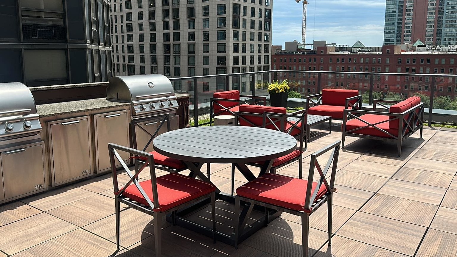 Inviting rooftop amenity deck at Sienna in Chicago, featuring grilling stations, an outdoor dining table, and comfortable lounge seating
