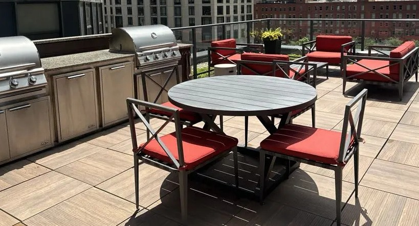Spacious rooftop deck at Sienna in Chicago, featuring stainless steel grills, outdoor dining, and comfortable lounge furniture with city views