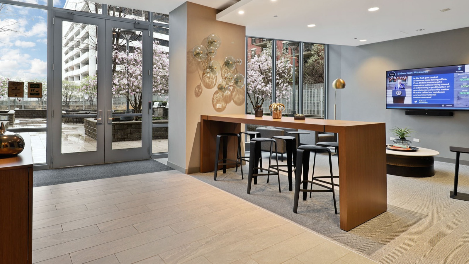 Inviting amenity lounge with a high-top table, stylish decor, and direct access to an outdoor terrace at SKY55 apartments in Chicago