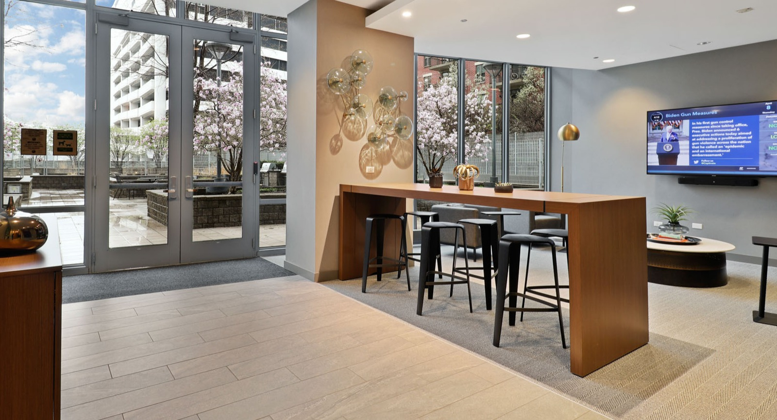 Inviting amenity lounge with a high-top table, stylish decor, and direct access to an outdoor terrace at SKY55 apartments in Chicago