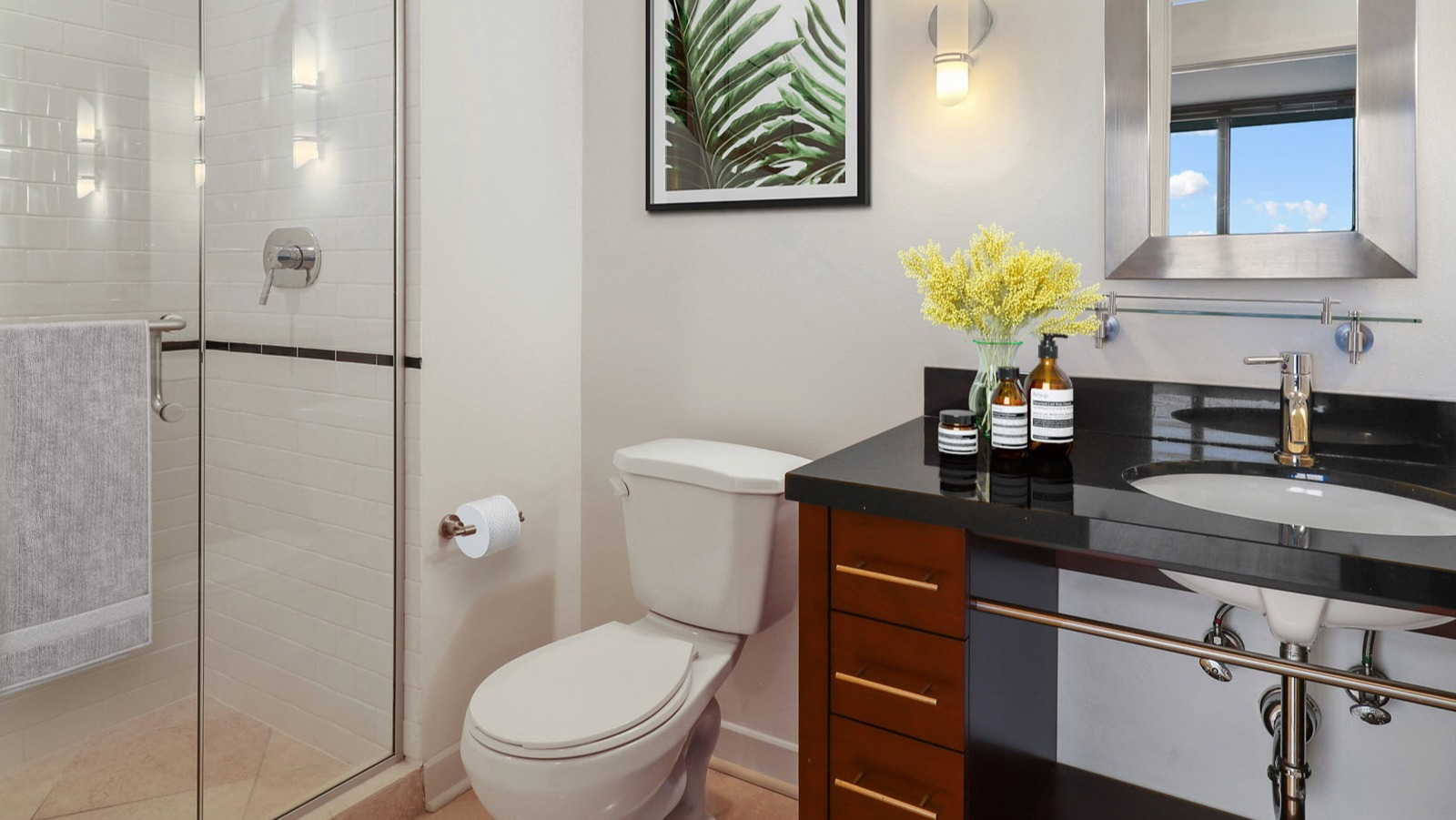 Modern guest bathroom at SKY55 in Chicago, featuring a sleek vanity, walk-in shower with white subway tiles, and contemporary fixtures
