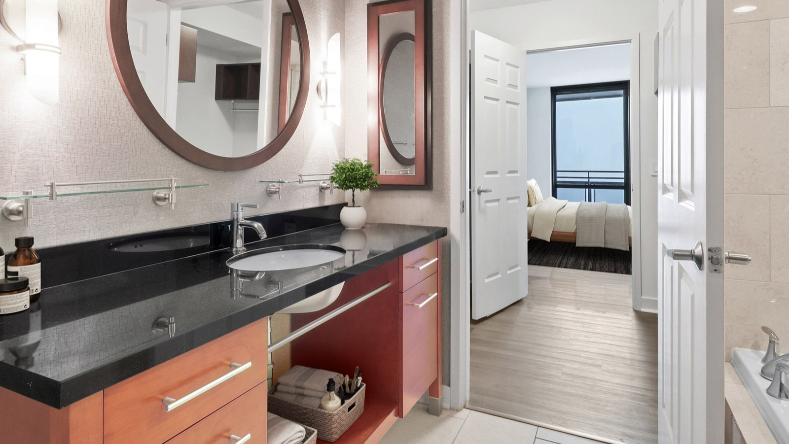 Stylish master bathroom at SKY55 in Chicago, featuring a contemporary vanity, large mirror, and access to an elegant bedroom