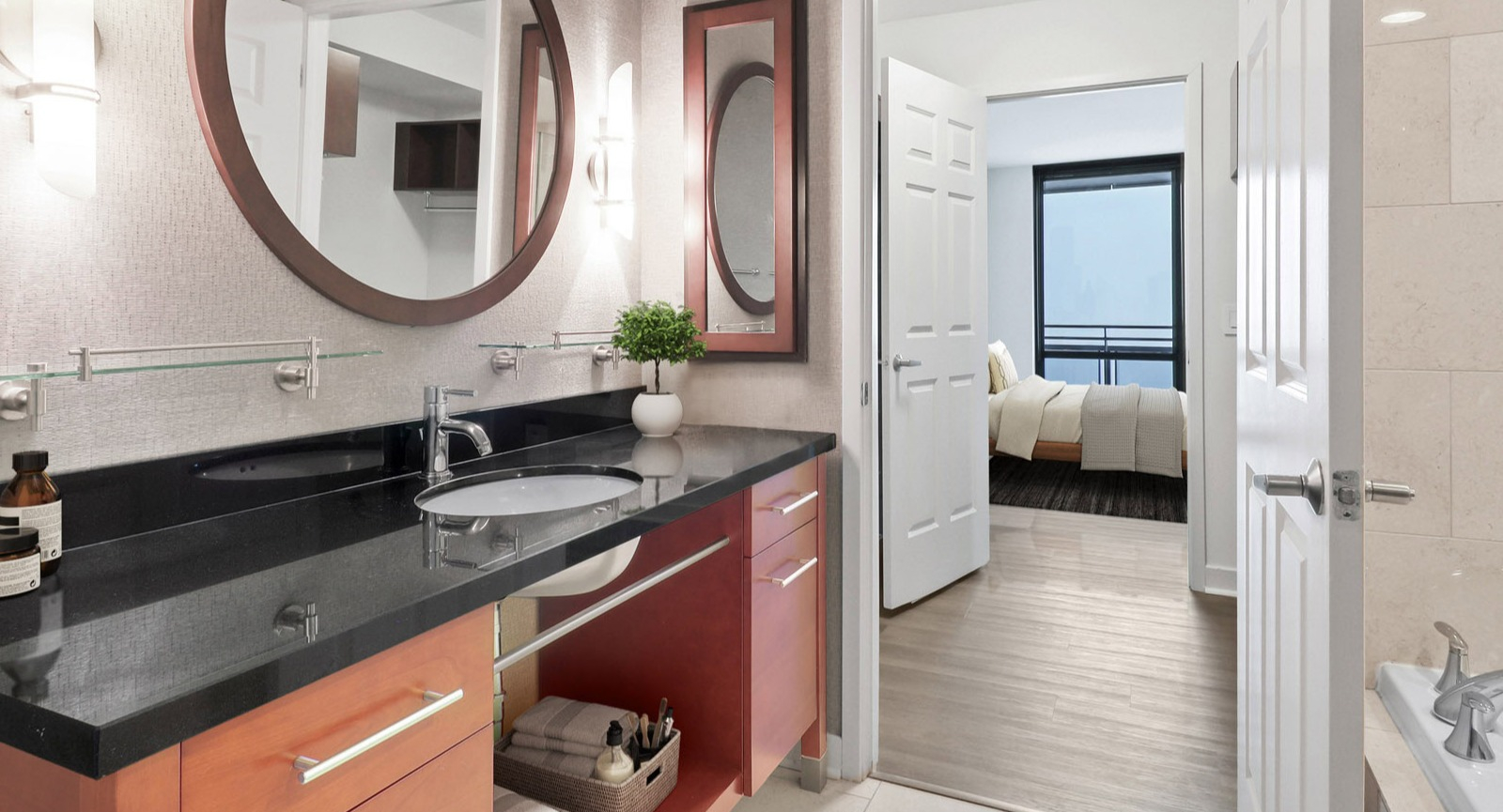 Stylish master bathroom at SKY55 in Chicago, featuring a contemporary vanity, large mirror, and access to an elegant bedroom