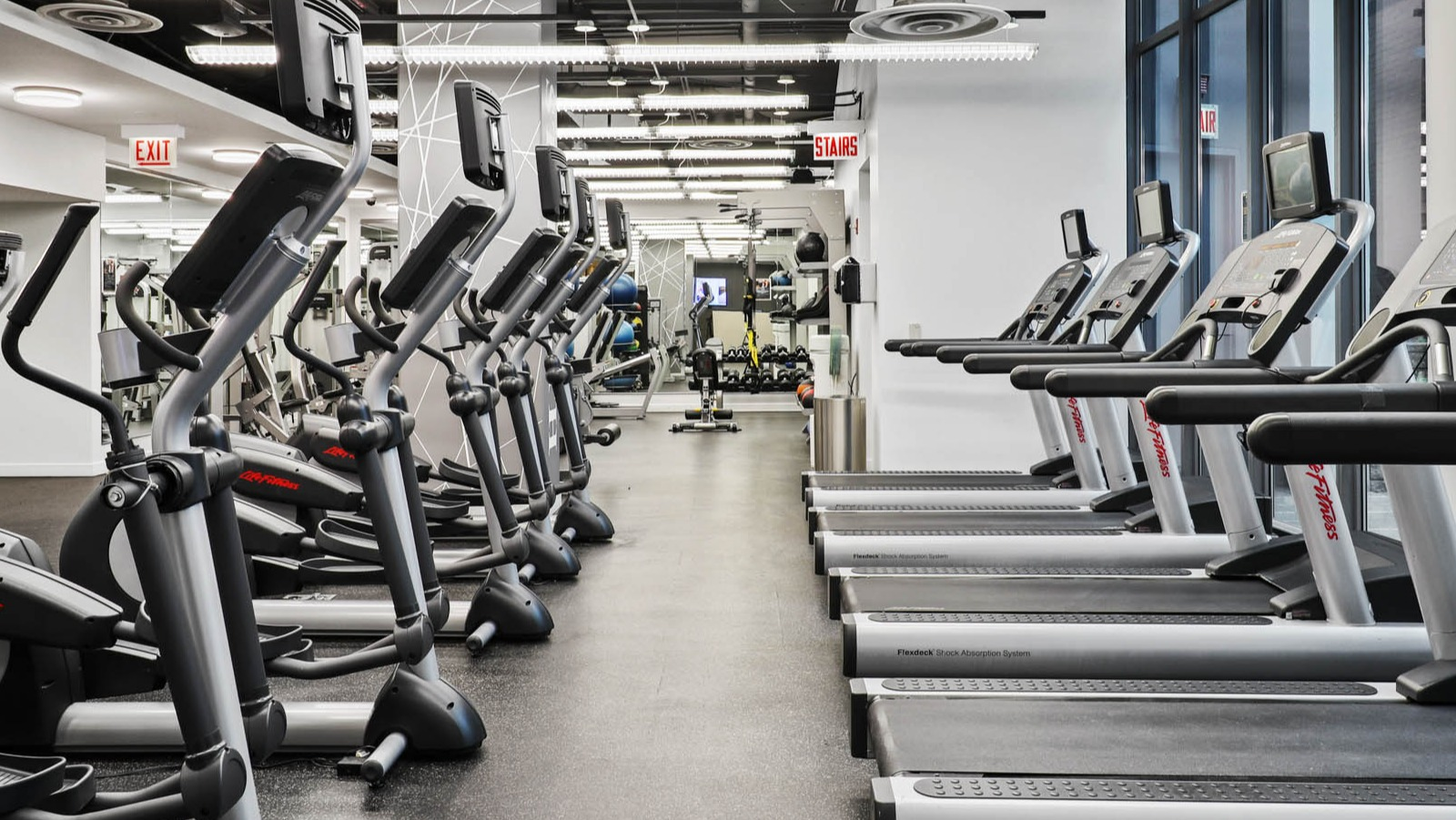 Spacious fitness center equipped with treadmills, ellipticals, and other cardio machines, perfect for a full workout at SKY55 apartments in Chicago