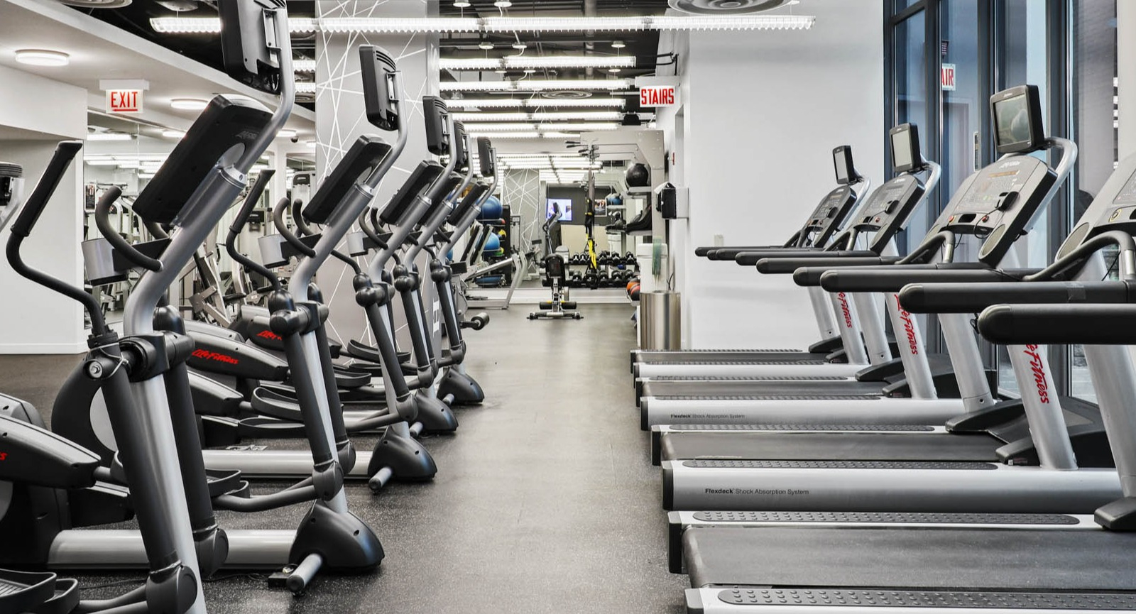 Spacious fitness center equipped with treadmills, ellipticals, and other cardio machines, perfect for a full workout at SKY55 apartments in Chicago