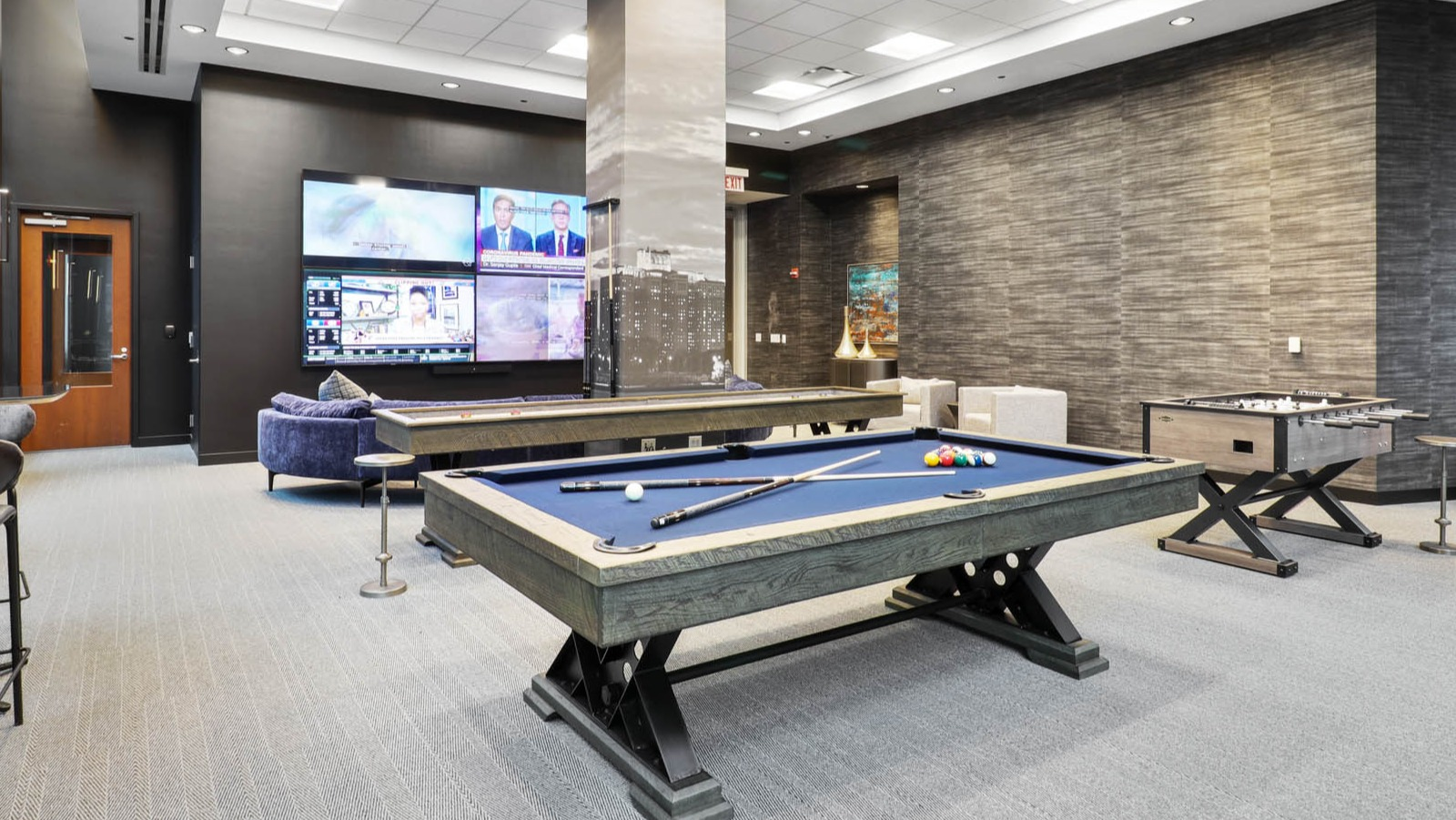 Fun game room featuring a billiards table, foosball table, and comfortable seating for resident entertainment at SKY55 apartments in Chicago