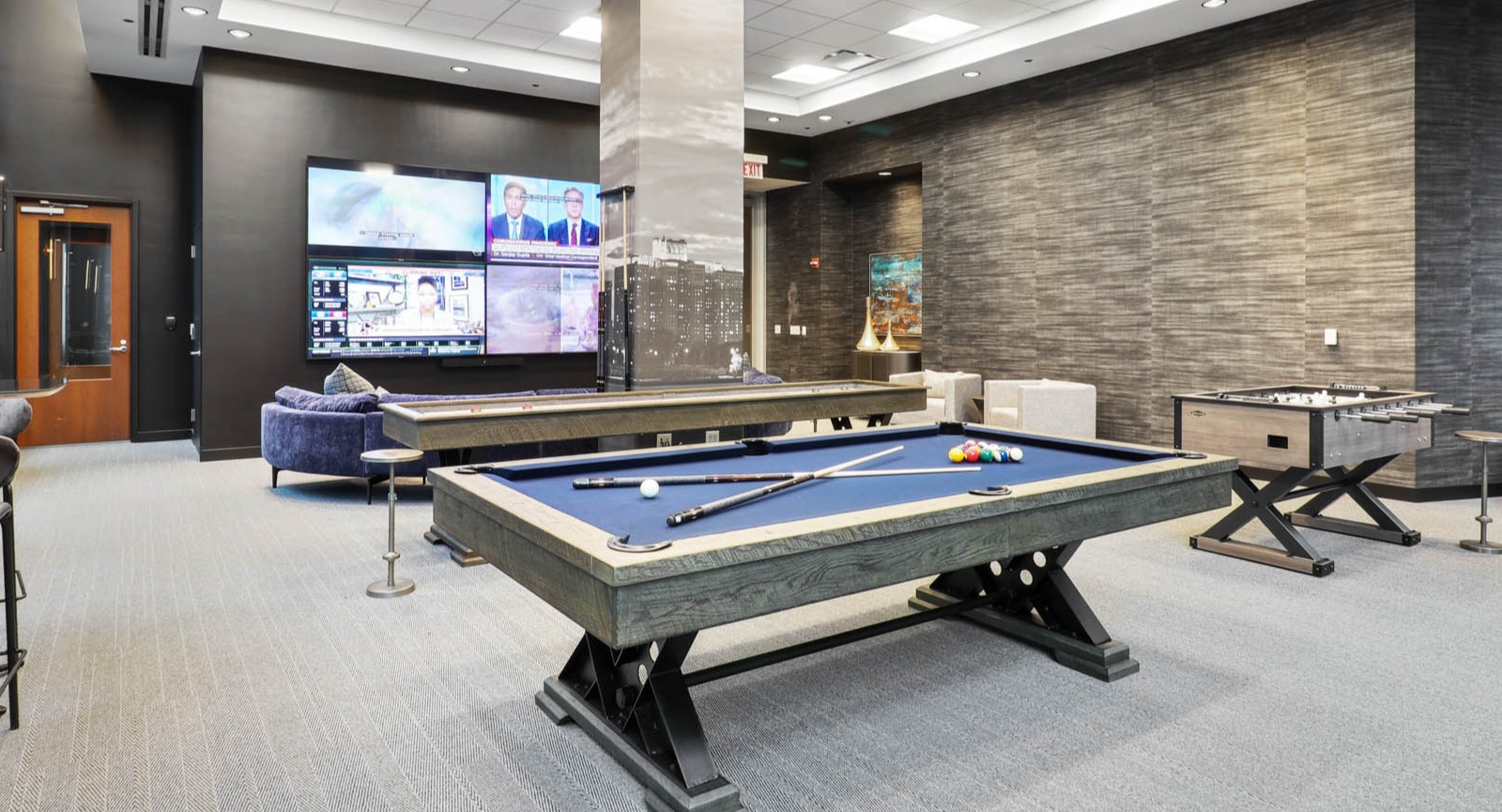 Fun game room featuring a billiards table, foosball table, and comfortable seating for resident entertainment at SKY55 apartments in Chicago