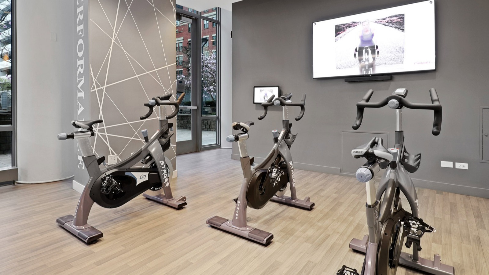 Modern spin studio with multiple exercise bikes and large windows providing natural light at SKY55 apartments in Chicago