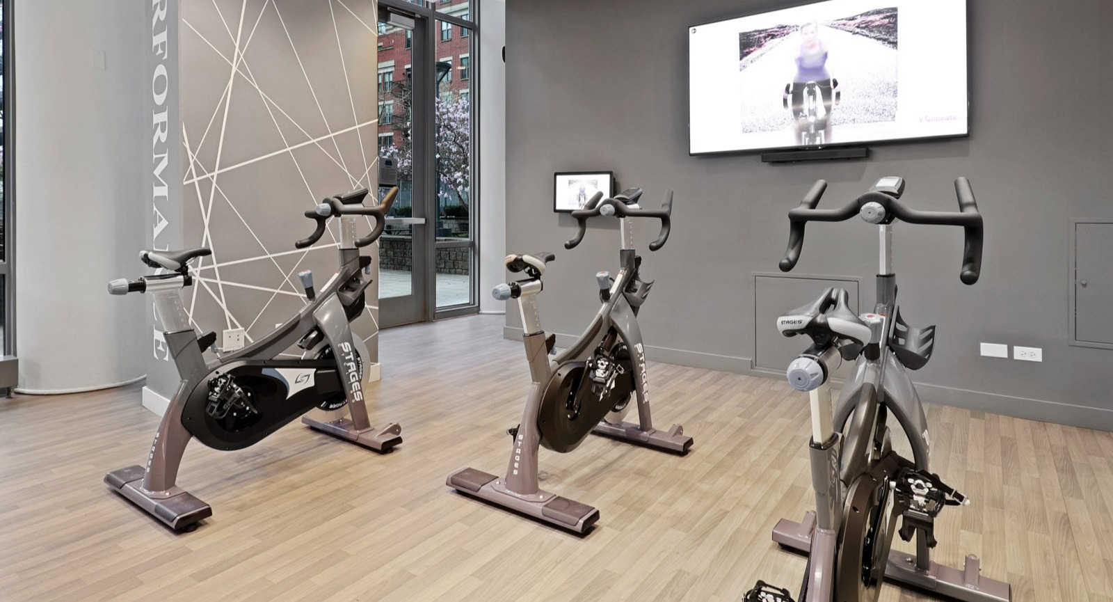 Modern spin studio with multiple exercise bikes and large windows providing natural light at SKY55 apartments in Chicago