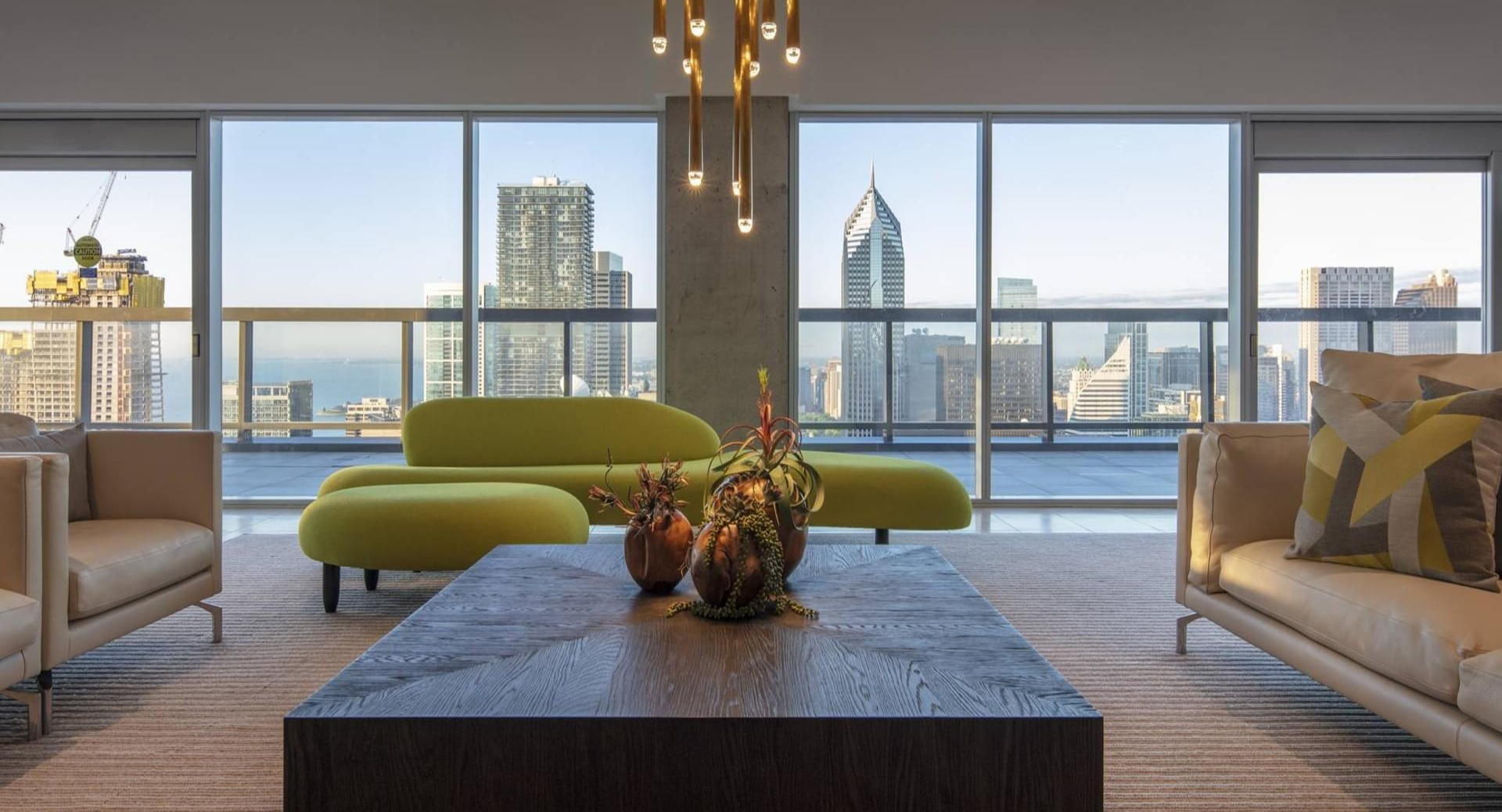 Skyline resident lounge with modern sofas, bold green seating, and panoramic views of Chicago at Optima Signature apartments