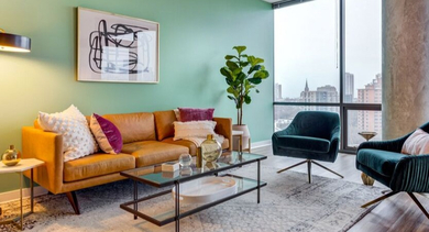 A stylish living area at SoNo East Apartments in Chicago, with a comfortable leather sofa and modern accent chairs