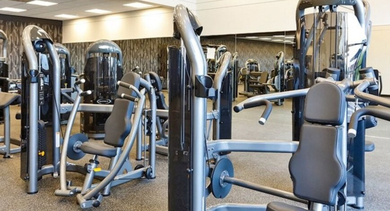 Comprehensive fitness center featuring various strength training machines and weights for residents at SoNo East Apartments in Chicago