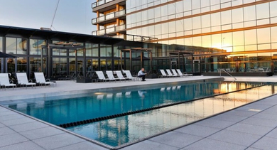 Beautiful rooftop pool deck at sunset with lounge seating and a modern building facade reflecting the golden light at SoNo East Apartments in Chicago