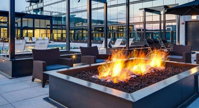 Inviting outdoor lounge area with a lit fire pit and comfortable seating, perfect for evening relaxation at SoNo East Apartments in Chicago