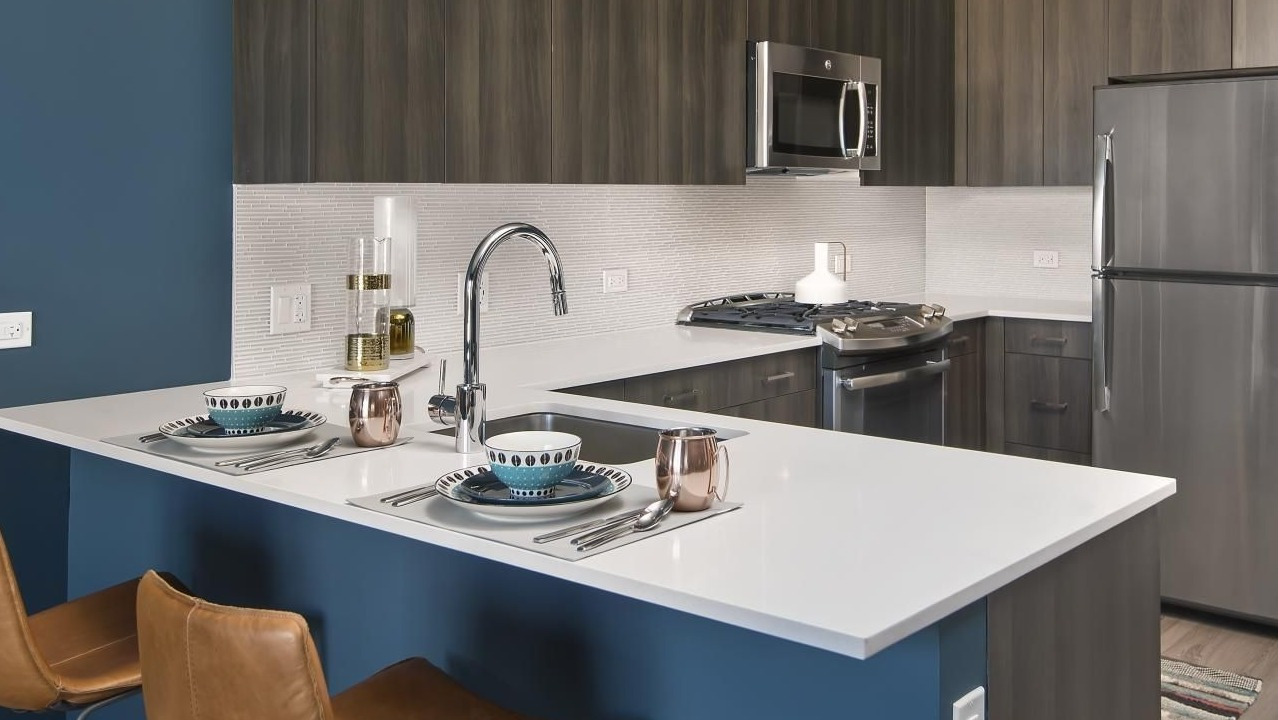 A contemporary kitchen at Spoke Apartments in Chicago, with a breakfast bar and stainless steel appliances