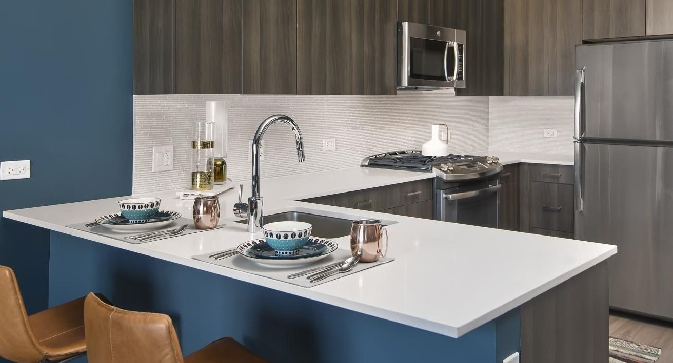 A contemporary kitchen at Spoke Apartments in Chicago, with a breakfast bar and stainless steel appliances