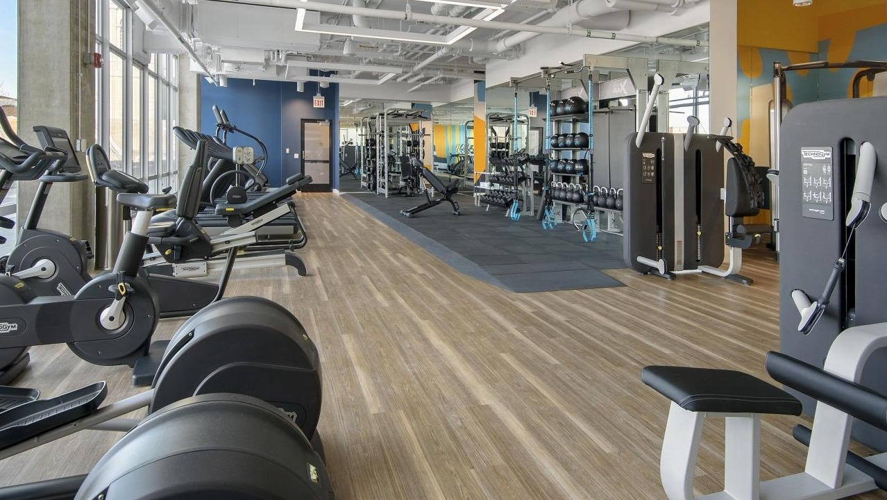 An expansive fitness center at Spoke Apartments in Chicago, featuring a wide range of cardio and strength training equipment