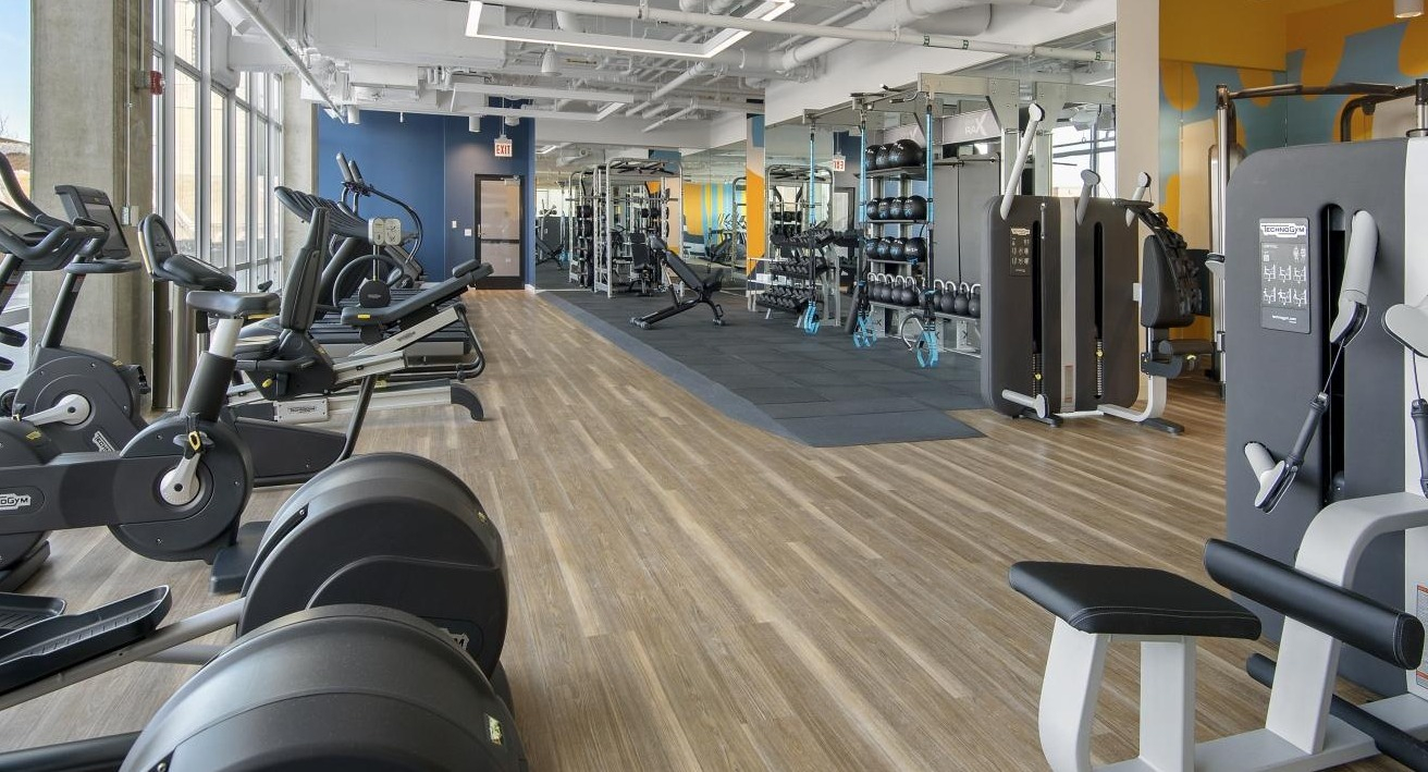An expansive fitness center at Spoke Apartments in Chicago, featuring a wide range of cardio and strength training equipment