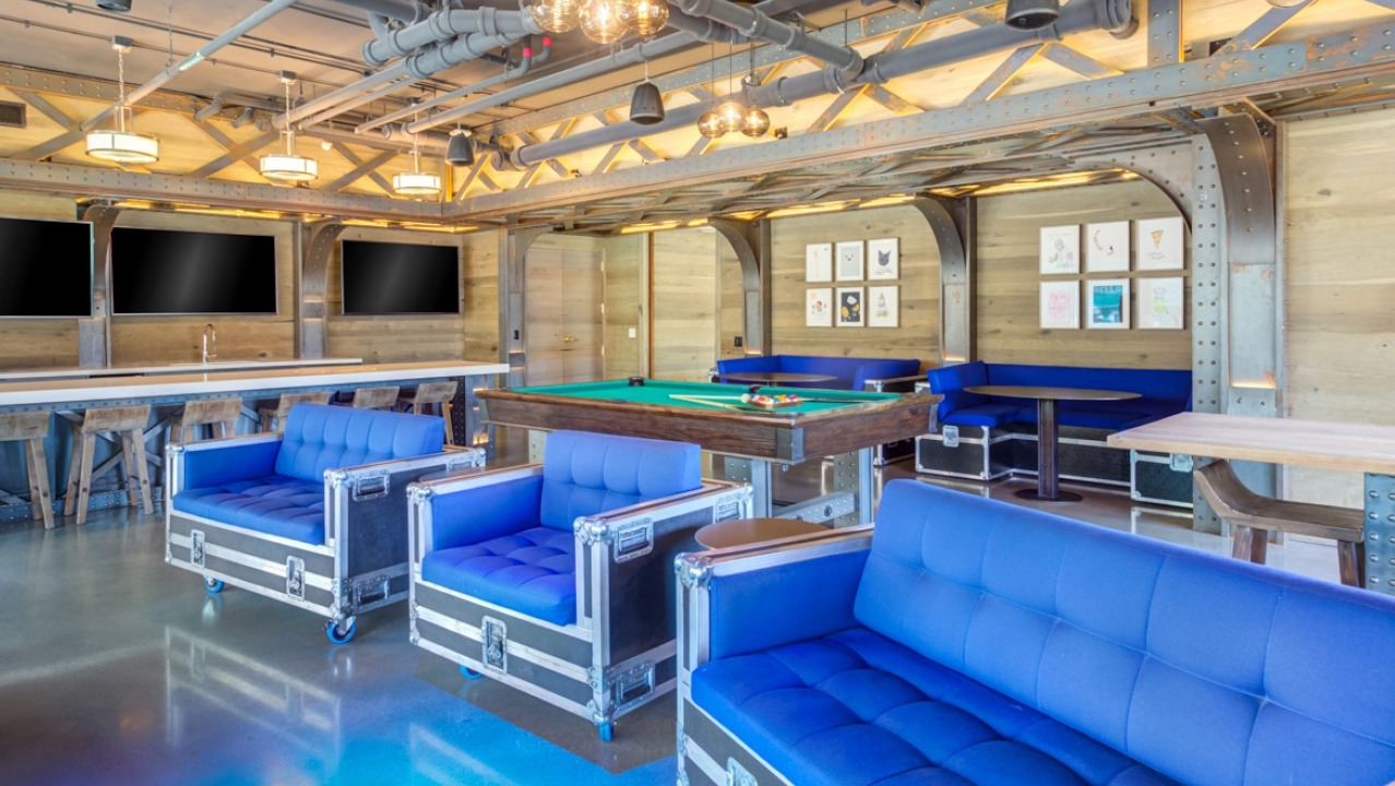 A fun game room and lounge at Spoke Apartments in Chicago, featuring a pool table and comfortable seating