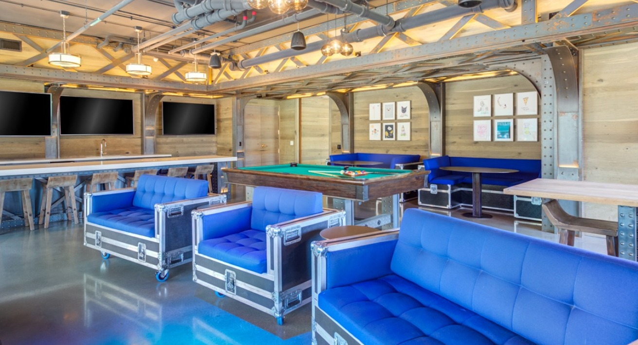 A fun game room and lounge at Spoke Apartments in Chicago, featuring a pool table and comfortable seating