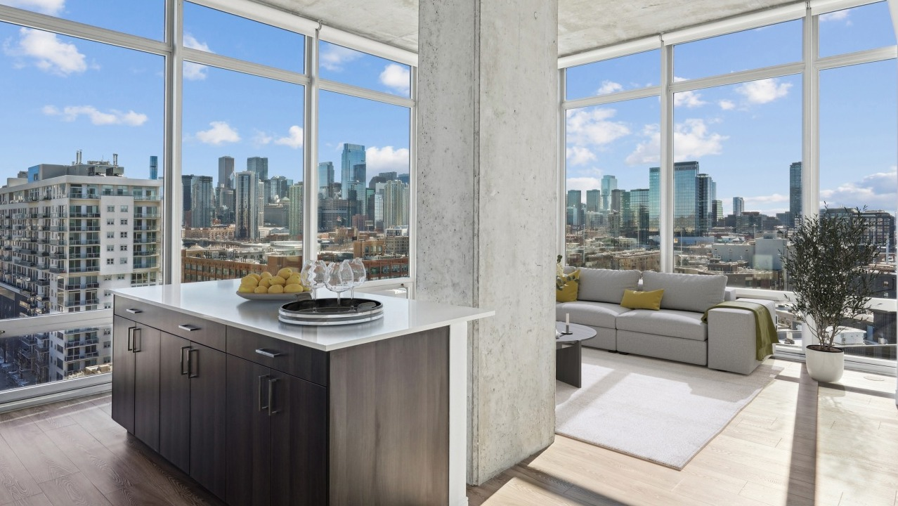 A luxury living space at Spoke Apartments in Chicago, featuring panoramic city views and a modern kitchen island