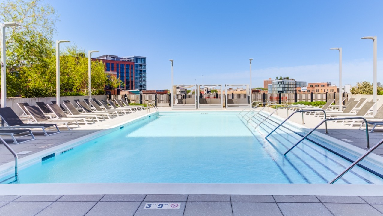 A vibrant outdoor pool and lounge area at Spoke Apartments in Chicago, perfect for sunbathing and relaxation