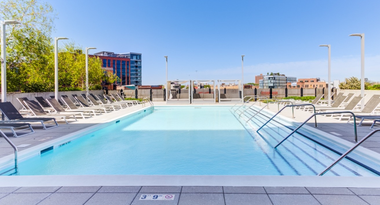 A vibrant outdoor pool and lounge area at Spoke Apartments in Chicago, perfect for sunbathing and relaxation